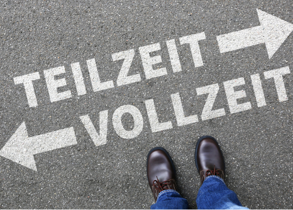 Blick von oben auf zwei Schuhe, auf dem Asphalt zwei Pfeile , rechts zu Teilzeit, links zu Vollzeit