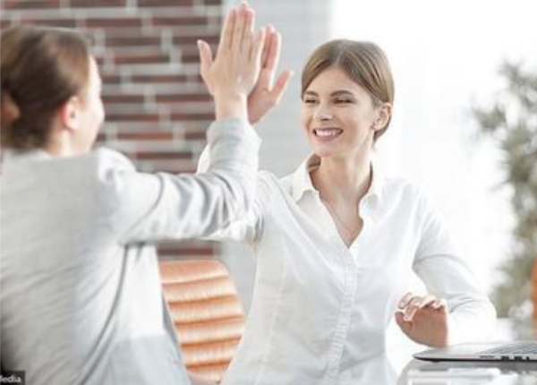 Zwei Frauen lachen sich mit einem "high-five" an